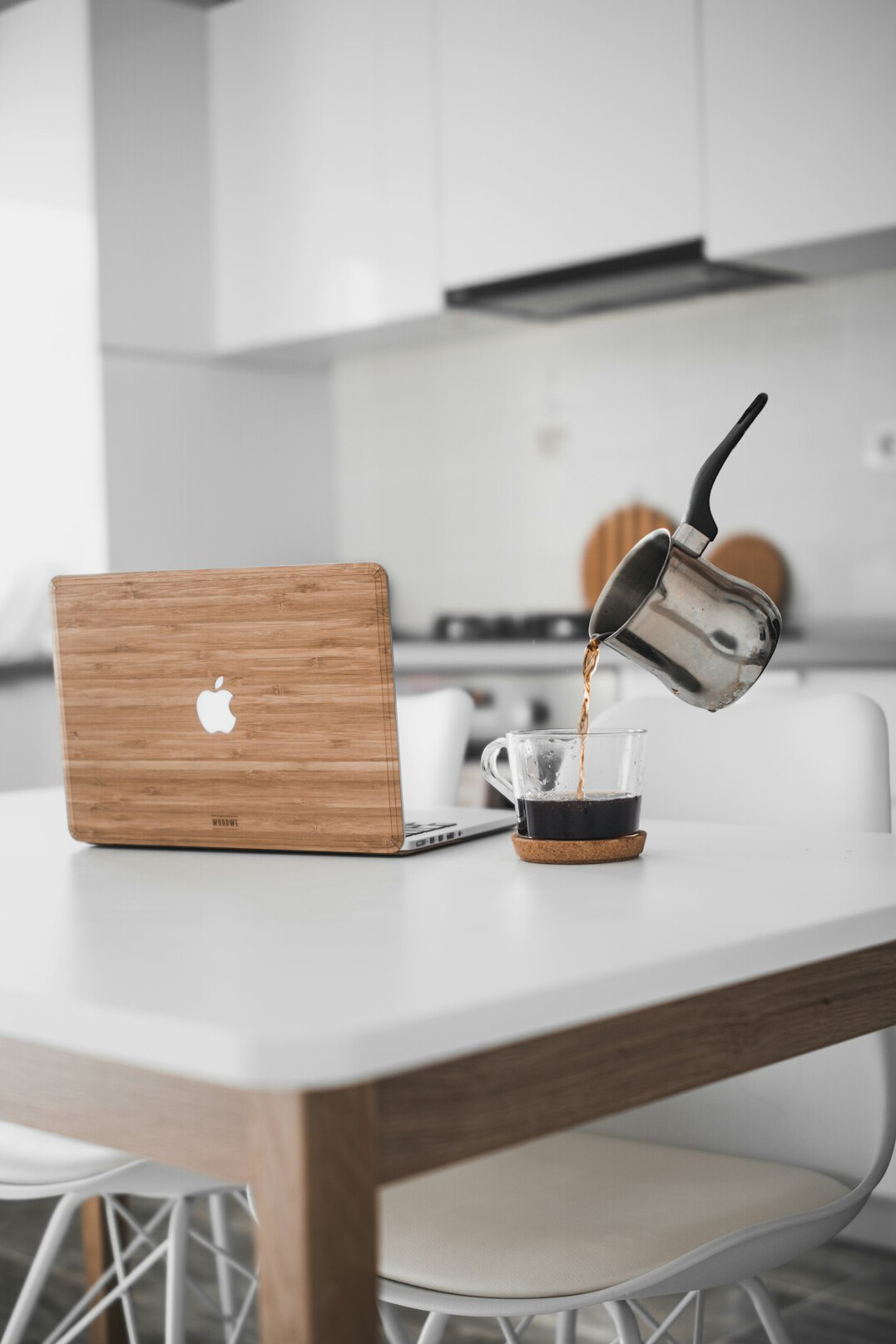 Laptop showing an email inbox on a desk with coffee